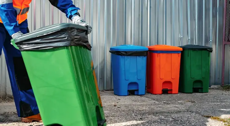 trash bins being collected by a sanitation worker